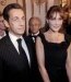Nicolas Sarkozy en costume rayé accompagné par Carla