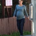 Natalie Portman affiche un ventre arrondi, enceinte de Benjamin Millepied, elle est habillée d'un simple jean, pull et tongs