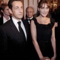 Nicolas Sarkozy en costume rayé accompagné par Carla