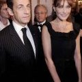 Nicolas Sarkozy en costume rayé accompagné par Carla