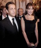 Nicolas Sarkozy en costume rayé accompagné par Carla