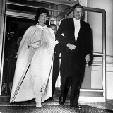 Jackie Kennedy en robe et cape blanche.