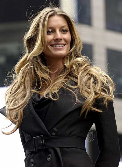 Gisèle Bündchen trench coat noir et cheveux ondulés