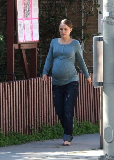 Natalie Portman affiche un ventre arrondi, enceinte de Benjamin Millepied, elle est habillée d'un simple jean, pull et tongs